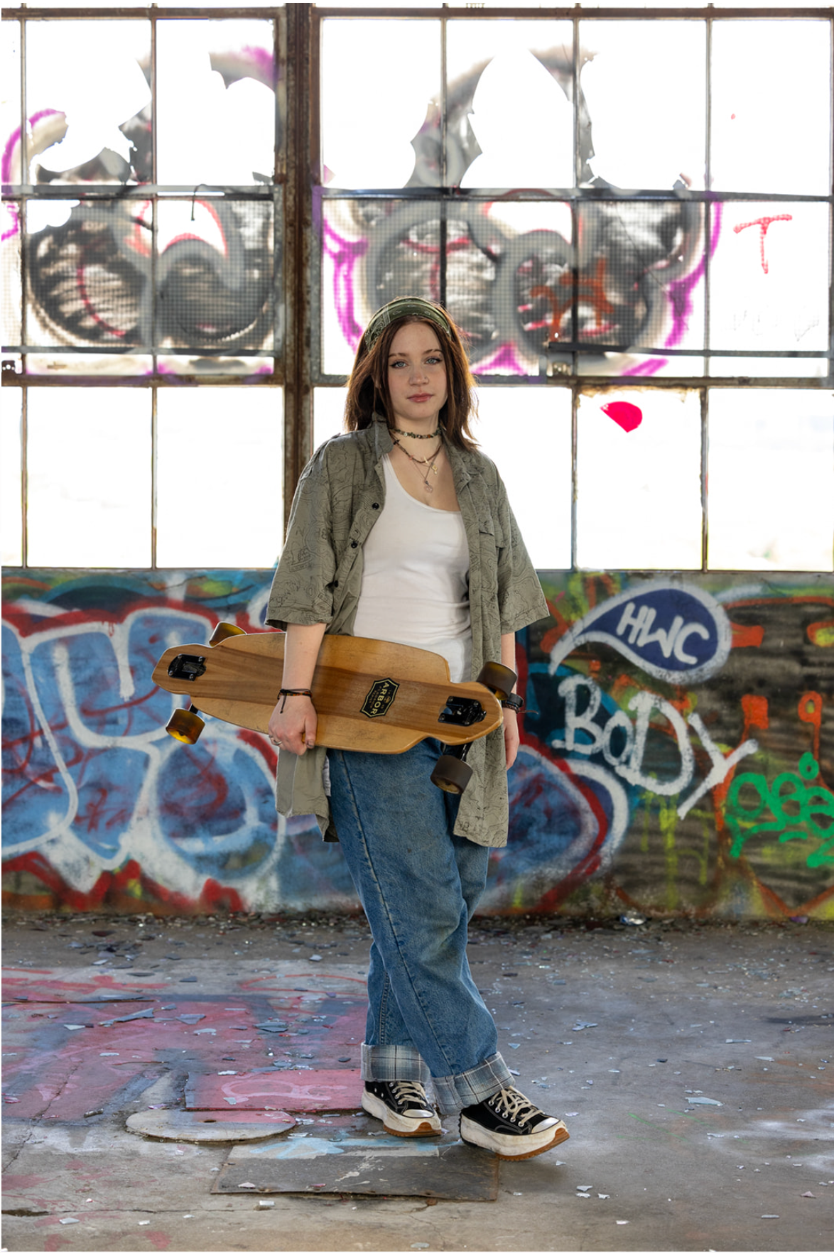 Great River School student Maria in her senior photos holding her skateboard captured by Malone Portraits in Minneapolis.